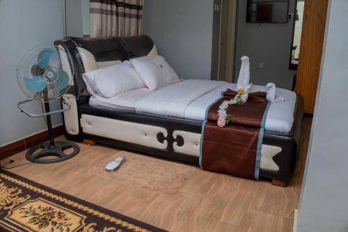 a bedroom with a bed and a fan and a floor at Jebel Hotel & Lounge Buloba in Kampala