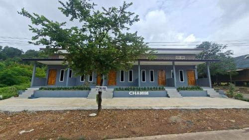 a house with a tree in front of it at Chamim Apartments Koh Lanta ชามิม in Phra Ae beach