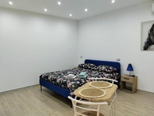 a bedroom with a bed and a table with chairs at Roca House in Valenzano