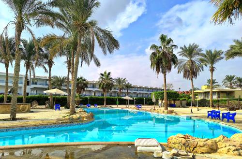 een zwembad met palmbomen en een resort bij شاليه 3 غرف للعائلات فقط Lasirena Mini Egypt Resort Ain Sokhna Families only in Ain Sokhna