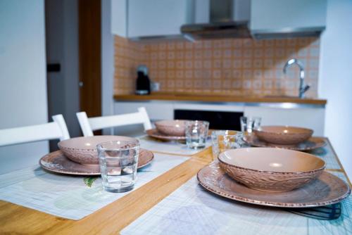 a wooden table with bowls and plates on it at GUBBIO LIVING - by Angeloni in Gubbio