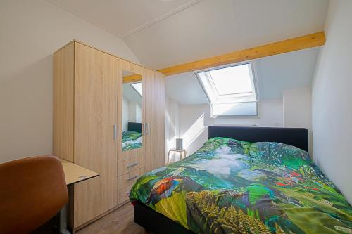 a bedroom with a bed and a desk and a window at New! Guesthouse Eindeloos in 't Zand