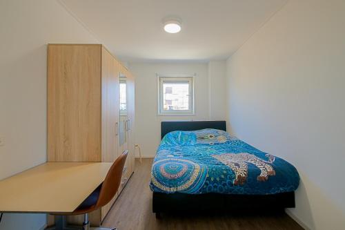 a small bedroom with a bed and a desk at New! Guesthouse Eindeloos in 't Zand