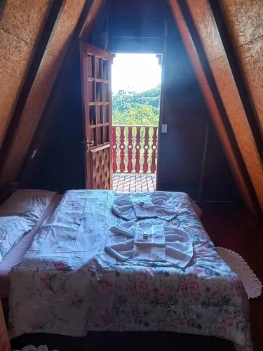 a bed in a room with a window at Recanto Mauá - Chalé Amarílis in Resende