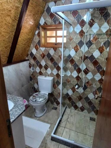 a bathroom with a toilet and a shower at Recanto Mauá - Chalé Amarílis in Resende