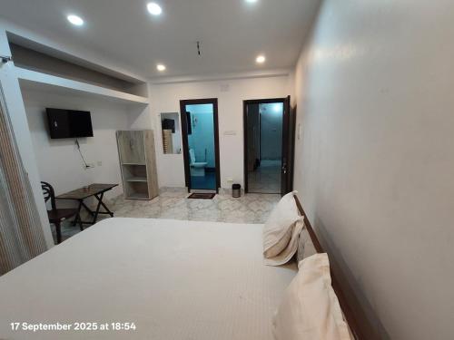 Un dormitorio con una cama y una habitación con una mesa. en Hotel AI Near Shalimar railway station, en Howrah