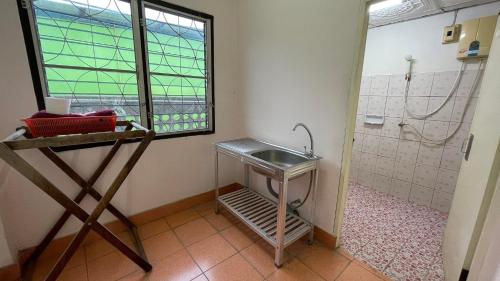 baño con lavabo y ducha con ventana en Thaen Thong Hotel, en Lamphun
