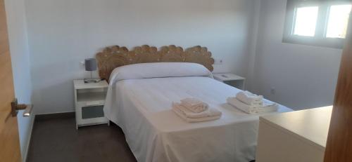 a bedroom with a bed with two towels on it at Casa Carmen in Serón