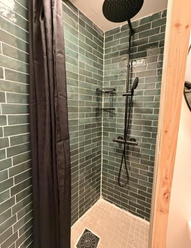 a bathroom with a shower with green tiles at CC`s Green house in Tromsø