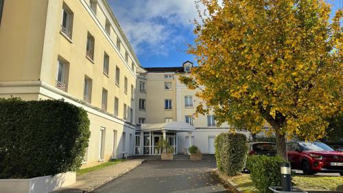 an empty street in front of a white building at Paris Home in Bussy-Saint-Georges