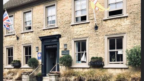 a stone building with a black door and a flag at Bridge House Hotel in Bridport
