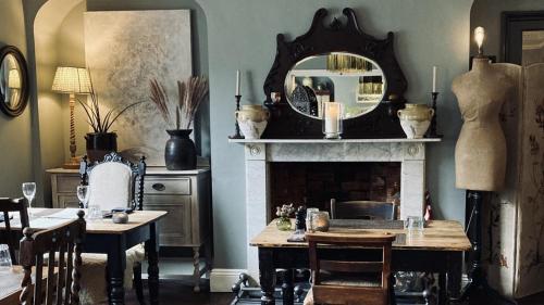 a dining room with a fireplace and a mirror at Bridge House Hotel in Bridport