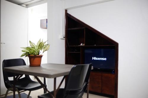 a table with chairs and a television in a room at sunny's homestay in Singatoka