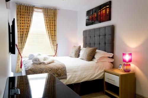a bedroom with a large bed with a window at Spacious 4 Bedroom Apartment in Oxford City Centre, Near Colleges & Botanical Gardens in Oxford