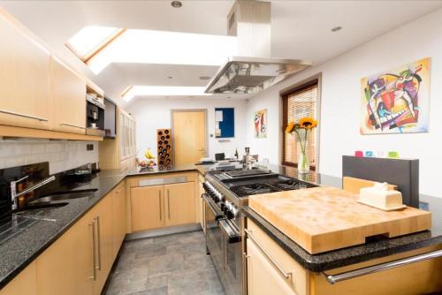 a large kitchen with a stove top oven at Spacious 4 Bedroom Apartment in Oxford City Centre, Near Colleges & Botanical Gardens in Oxford