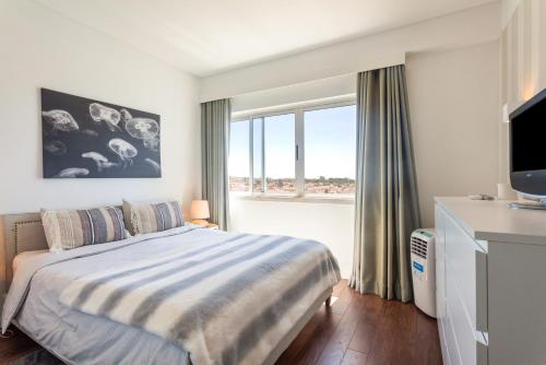 een slaapkamer met een bed en een groot raam bij one bedroom plus 1 extra room Nomad Dreams N6 in Cascais mountain view in Cascais
