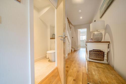 un couloir avec une salle de bains pourvue de toilettes. dans l'établissement Curlew Cottage, à Brancaster