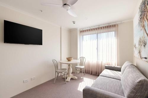 a living room with a couch and a table at King Bed with Sofa Bed Studio at Manly - 3min walk to Corso & Manly Beach in Sydney