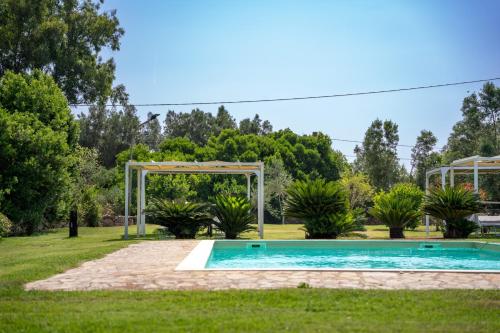 a swimming pool in a yard with a gazebo at Inghirios Wellness Country Resort in Santa Maria la Palma