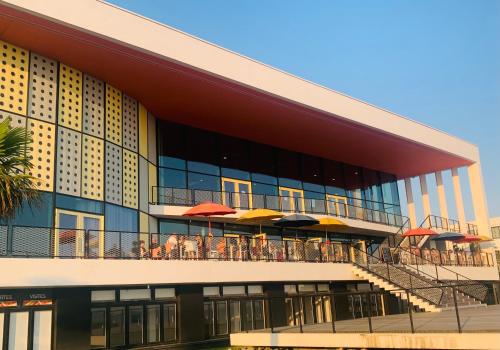 ein Gebäude mit Tischen und Sonnenschirmen auf dem Balkon in der Unterkunft Chambre & terrasse face océan in Royan