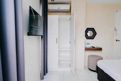 a bedroom with a bed and a tv and a door at Nine Balconies Island Stay in Boac