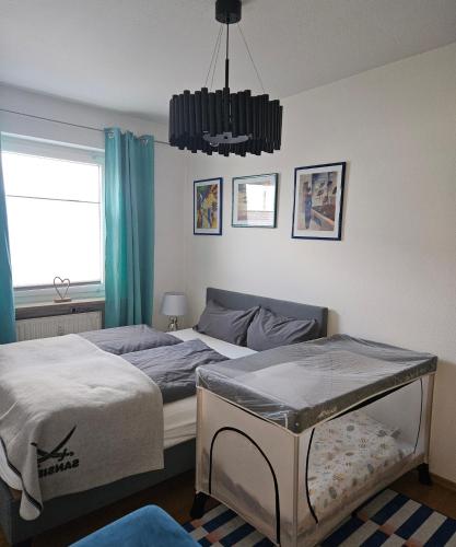 a bedroom with two beds and a chandelier at FeWo Viktoria in Bamberg