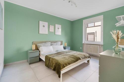 a green bedroom with a bed and a window at Moderne Traumwohnung mit Traumgarten in Mayen