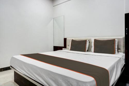 PhūrsungiにあるCollection O Aachal Hotel & Lodgingのベッドルーム(白い大型ベッド、茶色の枕付)