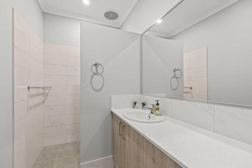 a white bathroom with a sink and a shower at Broome Villa Oasis in Broome