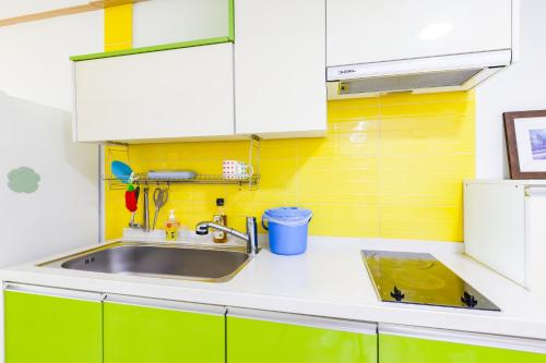 a kitchen with a sink and a yellow wall at 온담펜션 