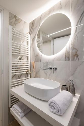 a white bathroom with a sink and a mirror at Maison Carola Sous Les Étoiles in Aosta