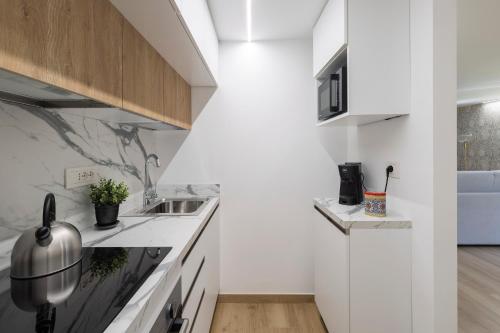 une cuisine blanche avec un évier et un comptoir dans l'établissement Maison Carola Sous Les Étoiles, à Aoste