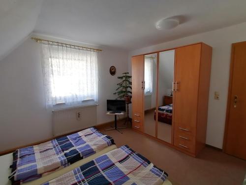 een slaapkamer met twee bedden en een spiegel bij Ferien im Haus am Waldrand in Freital