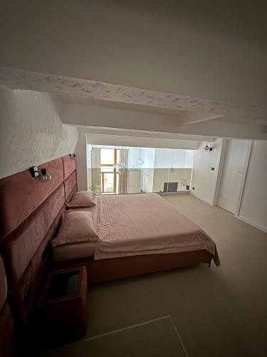 a bedroom with a large bed and a large window at Royal Loft Residence in Târgu Jiu