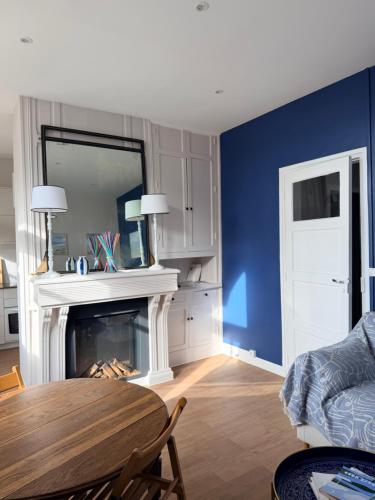 un salon avec une table et une cheminée dans l'établissement Charmant appartement en centre-ville, à Le Touquet-Paris-Plage