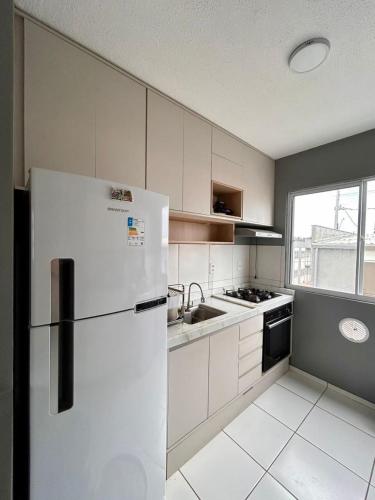 a white kitchen with a refrigerator and a sink at Apartment COP30 in Ananindeua