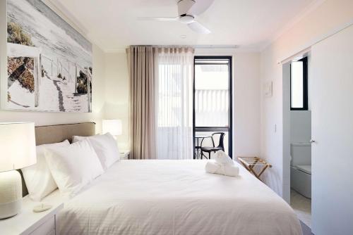 a white bedroom with a large bed and a window at Queen Bed with Balcony at Manly - 3min walk to Corso & Manly Beach in Sydney