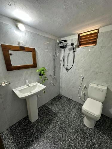 une salle de bains avec douche, toilettes et lavabo dans l'établissement Dimuthu Cottage Hiriketiya, à Dikwella