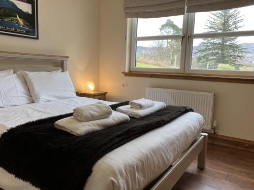 a bedroom with a bed with towels on it at Oiseval in Fort Augustus