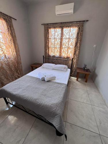 a bedroom with a bed and a window with curtains at PANKO Suite in Dhímitra