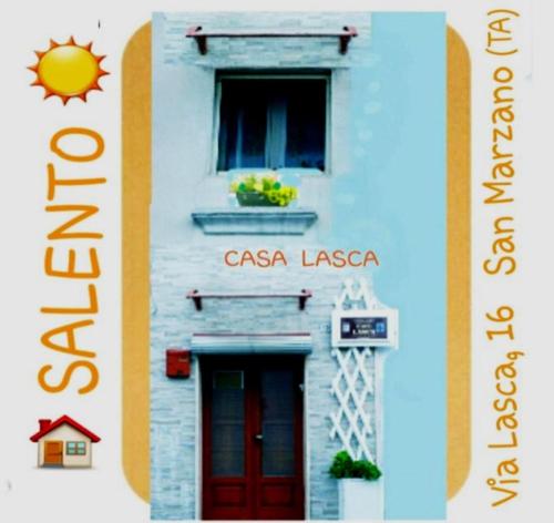 a sign for a casa liesta building with a red door at Casa Lasca in San Marzano di San Giuseppe