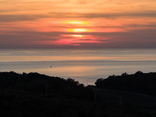 a sunset over the ocean with the sun in the sky at Cape of Rodon Resort, Green Village in Draçi