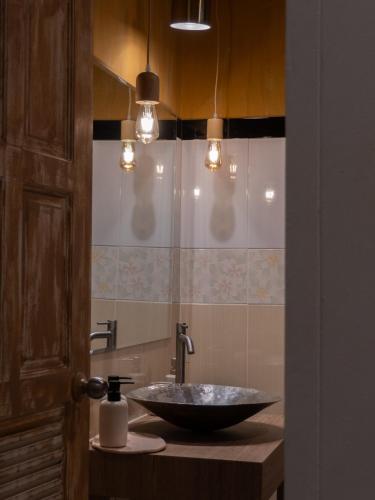 a bathroom with a bowl sink and a mirror at The Fifth Bamboo in Laguna Phuket