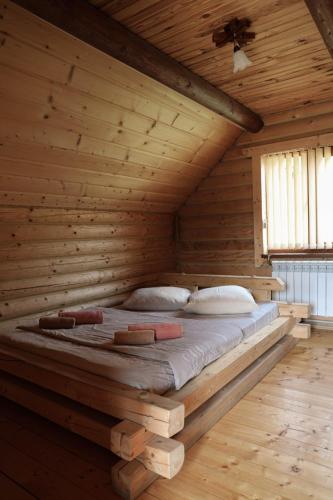 a bed in a wooden room in a log cabin at Котедж Арніка з Чаном in Vorokhta