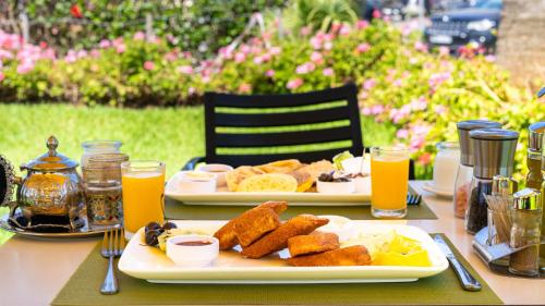 丹吉尔MIRANDA HOTEL - Tanger的桌上的两盘食物和橙汁