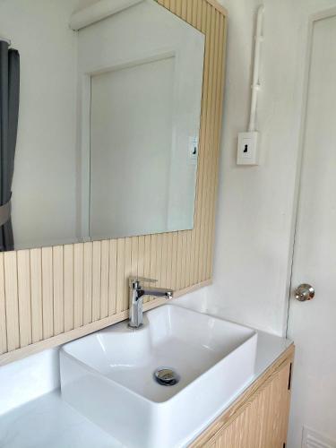 a bathroom with a white sink and a mirror at Pause Homestay 2 Hat Yai in Hat Yai
