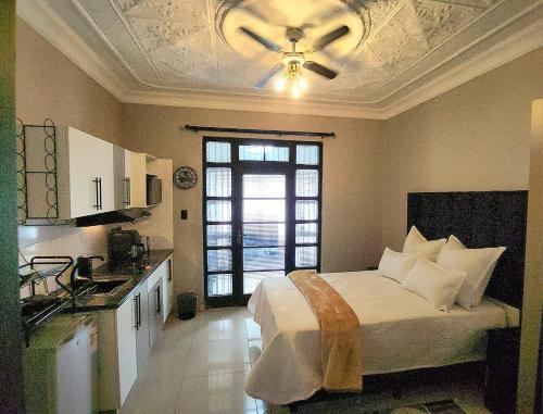 a bedroom with a bed and a ceiling fan at WinHaven Guest House in Randfontein