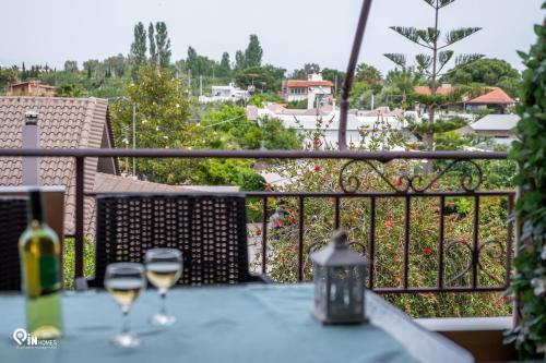 zwei Gläser Wein auf einem Tisch auf einem Balkon in der Unterkunft The Seagull - Quiet Retreat With Panoramic View in Nea Makri
