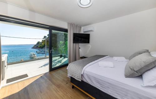 a bedroom with a bed and a view of the ocean at Villa Palazzo Maestral beachfront by Villas Guide in Viniština