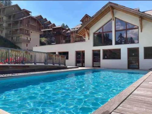 una piscina frente a una casa en Chalet Des Rennes - Super appartement Prestige dans une résidence avec piscine au pied des pistes, en Vars
